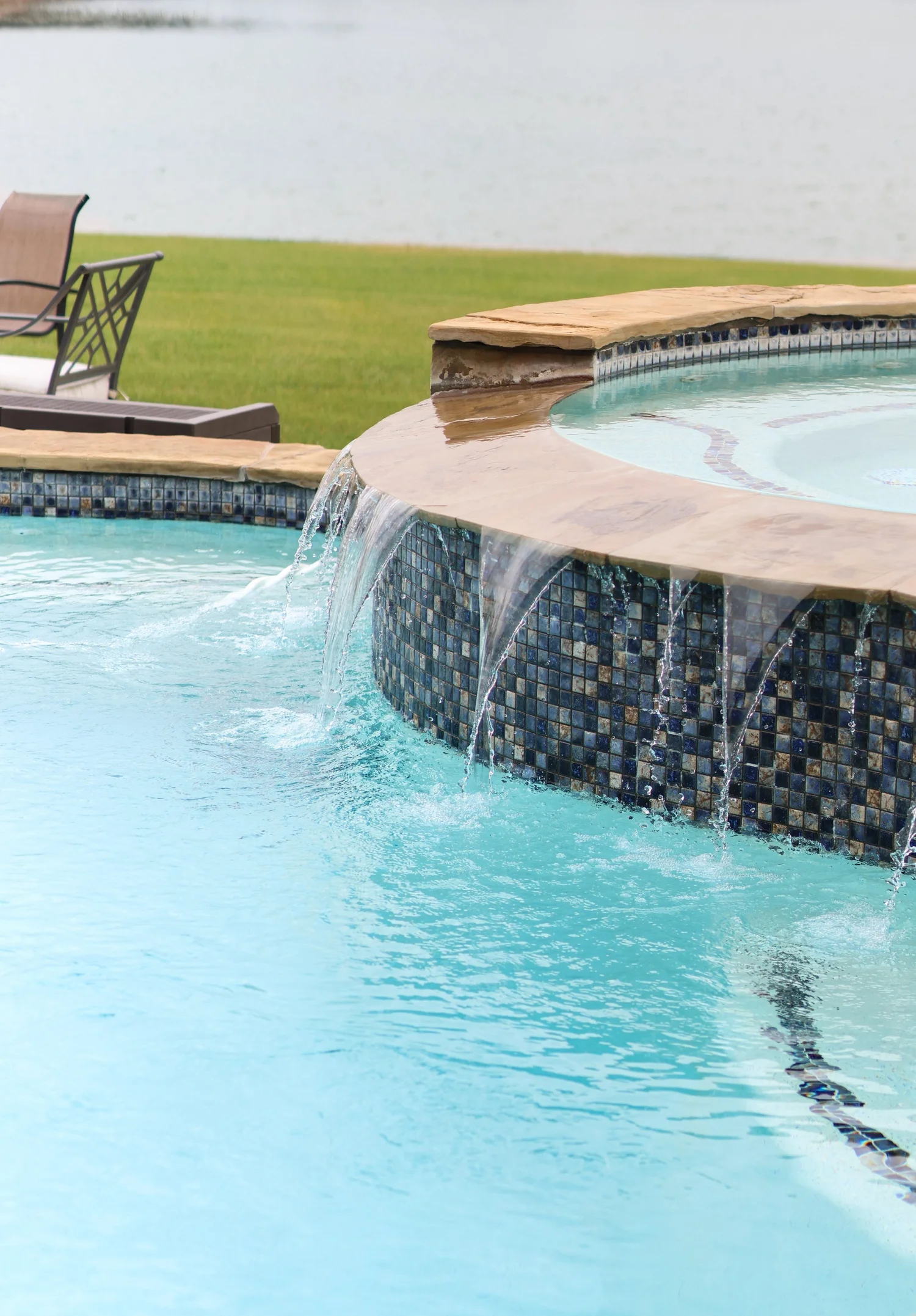 A clean pool with a cascading water feature